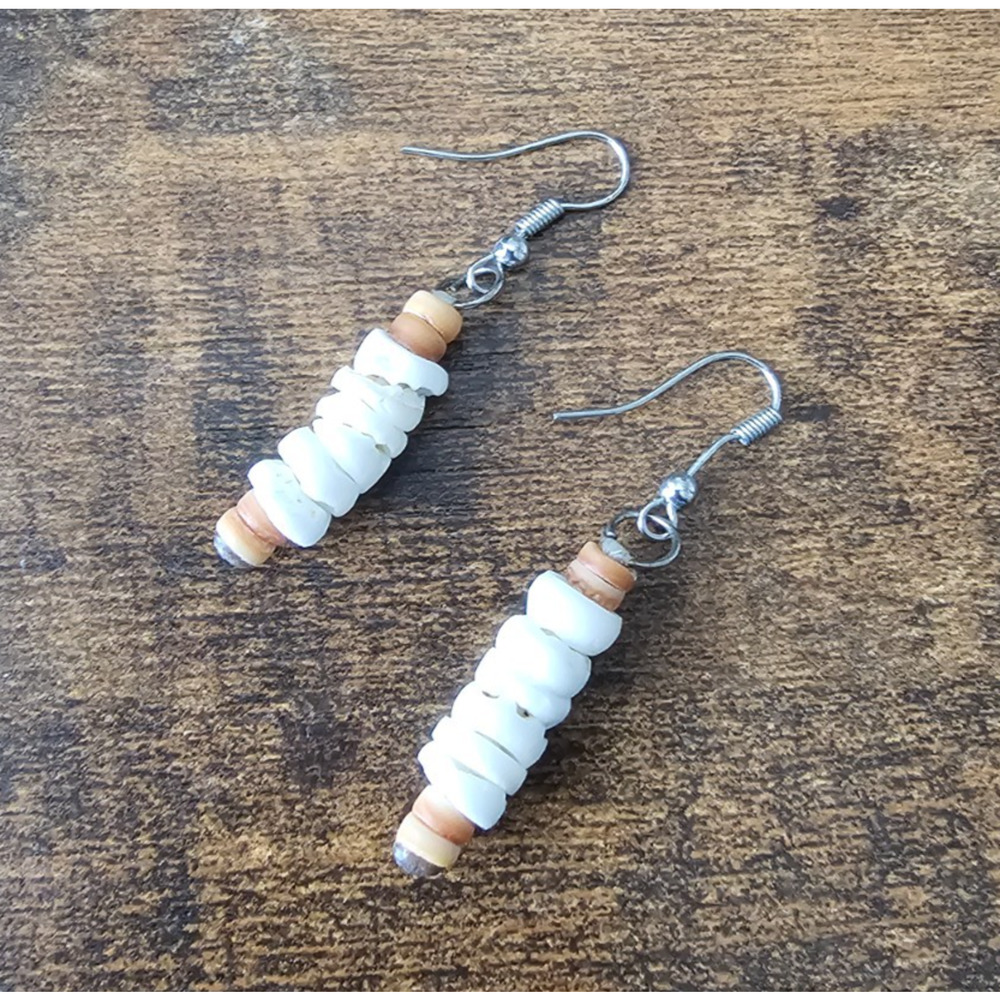 Handcrafted puka shell chip dangle earrings featuring stacked white shell pieces